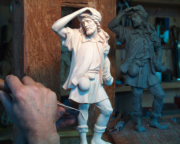 The sculptor first creates a clay model, which is then carved in wood